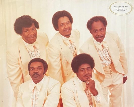 The group in the 1970s, in cream suits