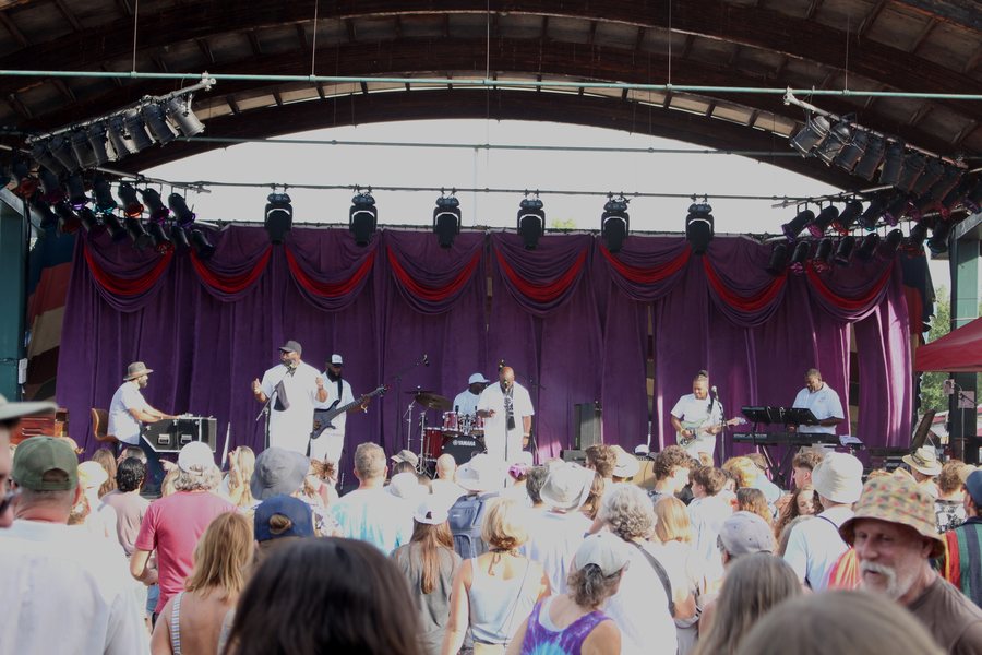 The band on a festival main stage playing to a packed crowd
