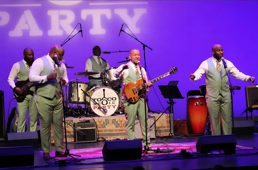 The group performing on a theater stage